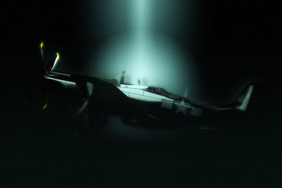 Side view of illuminated airplane at night