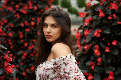 Portrait of beautiful woman with red flowers