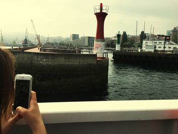 Man photographing with mobile phone in city