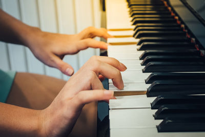 Cropped image of hands playing piano