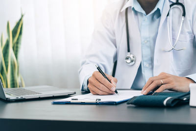 Midsection of person wearing mask on table