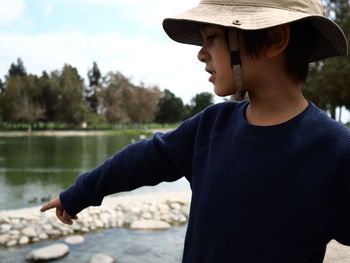 Close-up of boy gesturing while wearing sun hat