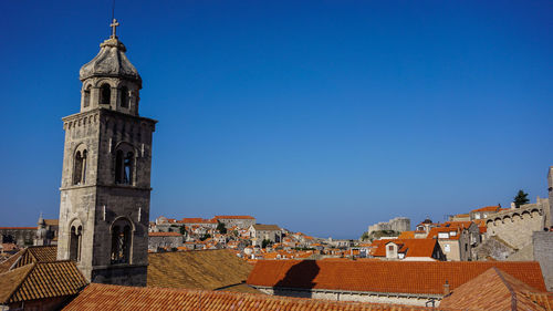 Buildings in city against clear blue sky