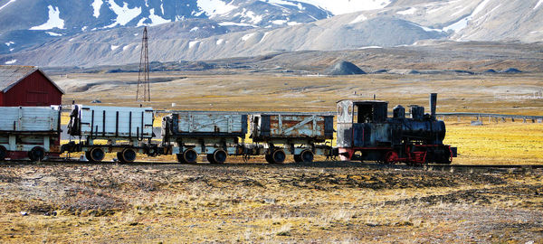 Train on field against mountain range