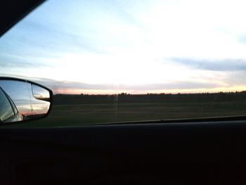 Close-up of car on landscape against sky