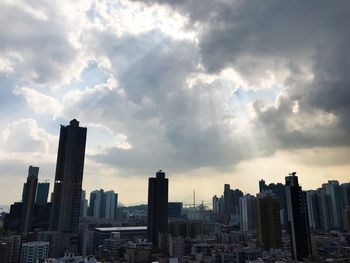 Skyscrapers against cloudy sky