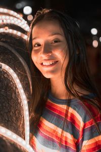 Portrait of smiling young woman at night