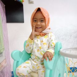 Portrait of smiling girl sitting outdoors