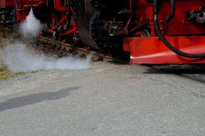 Steam train emitting smoke on road