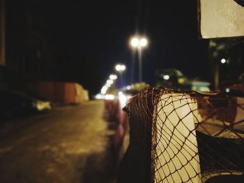 Close-up of illuminated lighting equipment on street at night