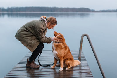 Side view of man with dog on pier