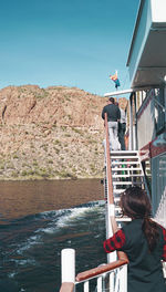 Rear view of woman on shore against clear sky