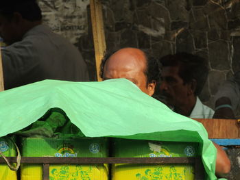 Close-up portrait of man with people in foreground