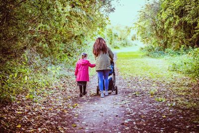 Rear view of girls walking in forest