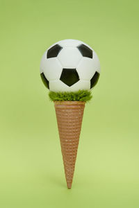 Close-up of ball on table against green background