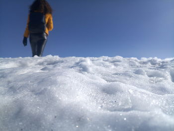 Surface level on woman walking on snow covered land