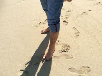 Low section of man standing on shore