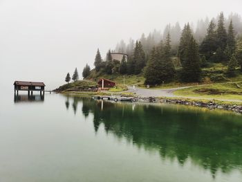 Scenic view of lake by building against sky