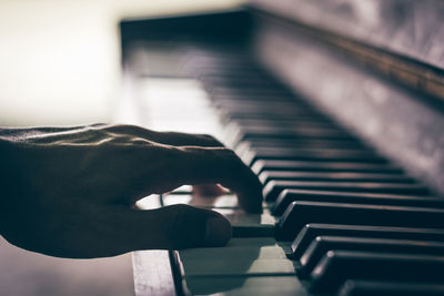 Cropped image of person playing piano