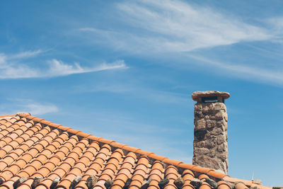 Low angle view of chimney on roof against sky
