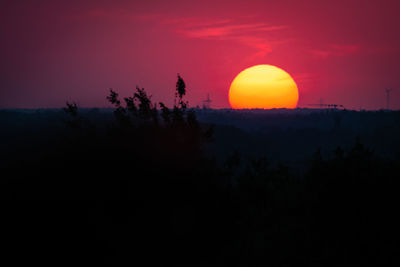 Scenic view of silhouette landscape against orange sky