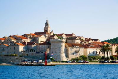 Buildings in city against clear sky