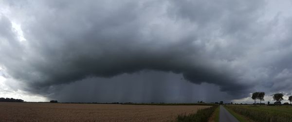 Panoramic view of storm clouds over field