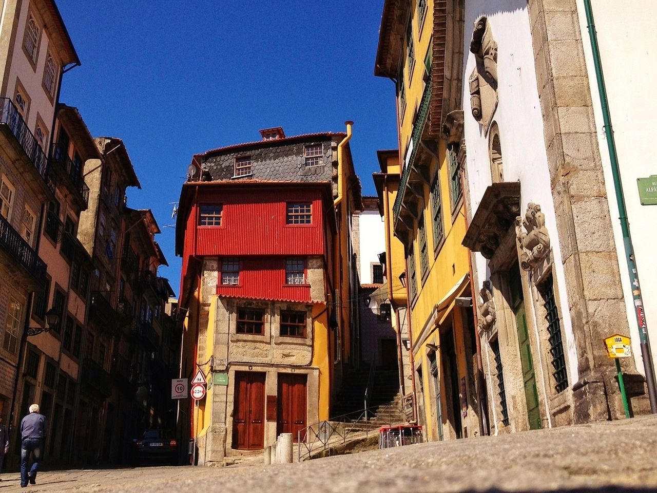 building exterior, architecture, built structure, clear sky, residential structure, residential building, building, low angle view, city, street, house, window, sunlight, day, outdoors, sky, city life, blue, exterior, old town