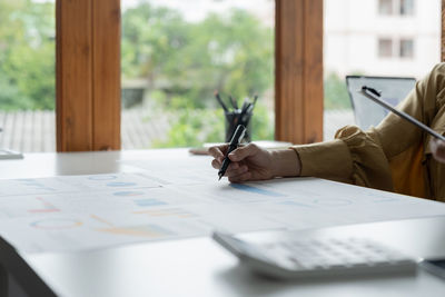 Midsection of business colleagues working at desk in office