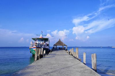 Pier over sea against blue sky