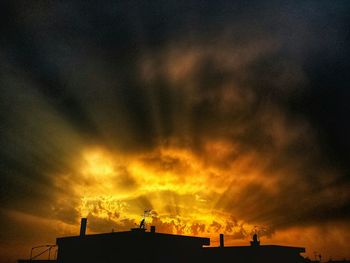 Silhouette of built structure against cloudy sky