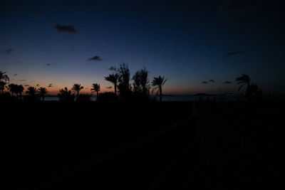 Silhouette trees on landscape against clear sky