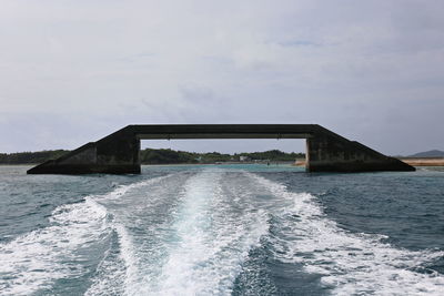 Built structure in okinawa in the sea, against sky