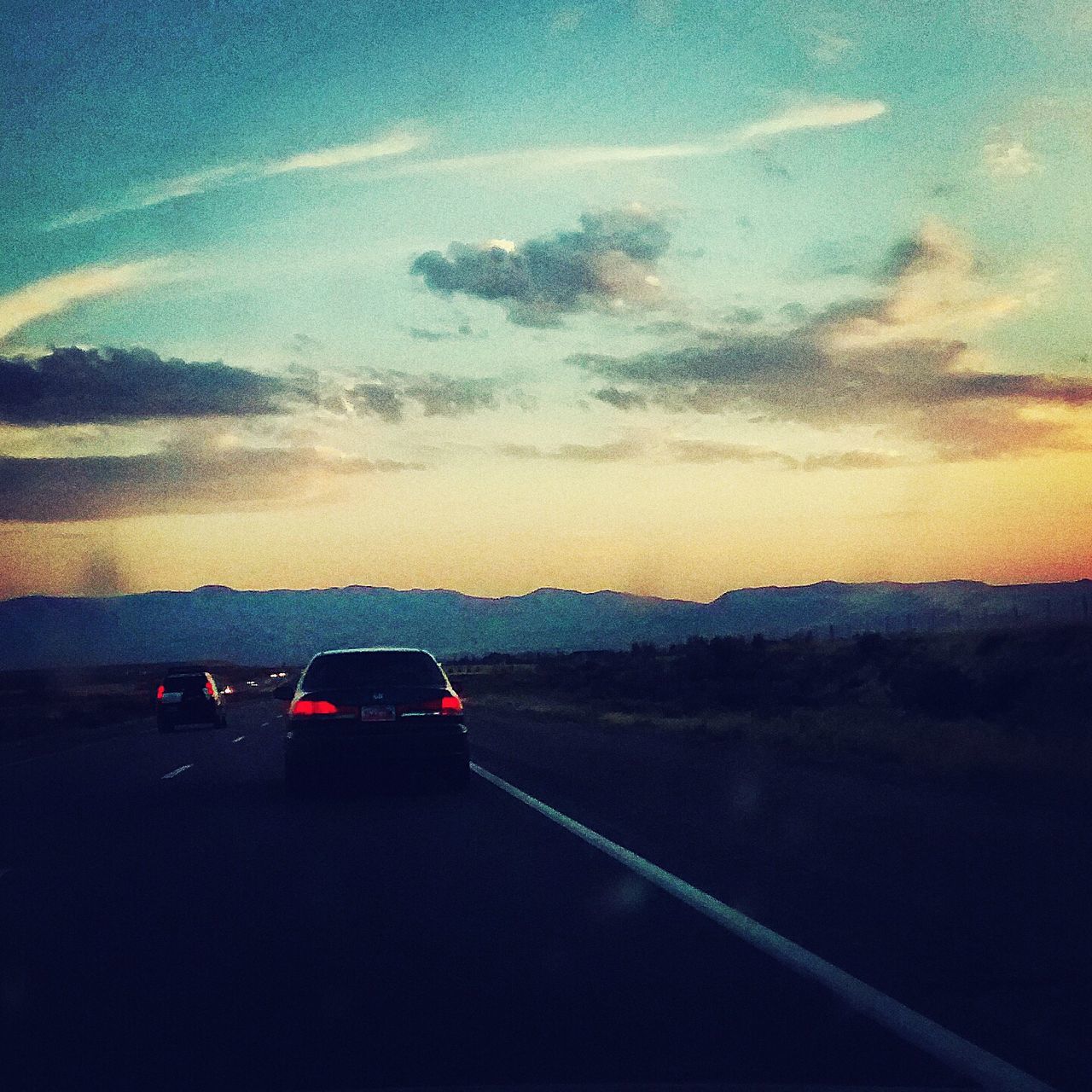 transportation, mode of transport, land vehicle, car, road, sky, sunset, on the move, cloud - sky, road marking, landscape, travel, scenics, beauty in nature, cloud, nature, tranquil scene, mountain, tranquility, the way forward