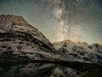 Low angle view of snowcapped mountains at night