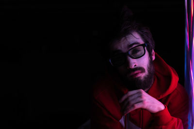 Portrait of young man against black background