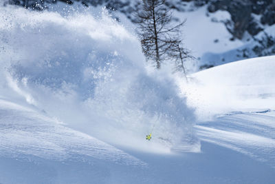 Ski pole sticking out of snow spray, man skiing in deep powder snow, zauchensee, salzburg, austria