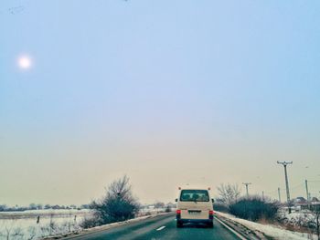 Cars on road against sky in city