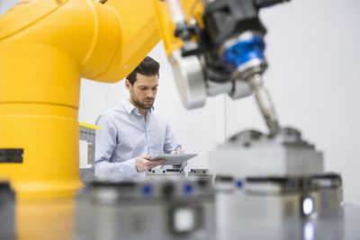 Young businessman checking automated production in factory