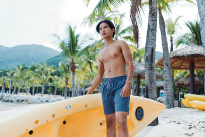 Portrait of shirtless man swimming in sea