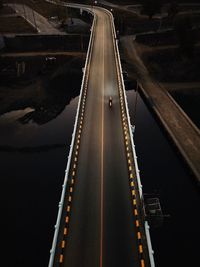 High angle view of empty bridge over road in city at night