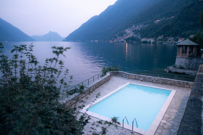 Scenic view of lake by mountains against sky