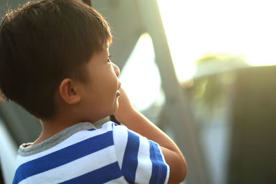 Close-up of cute boy looking away outdoors