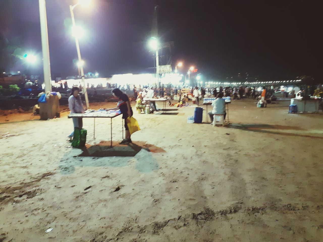 CROWD AT BEACH AGAINST SKY AT NIGHT