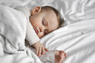 Cute baby sleeping on bed at home
