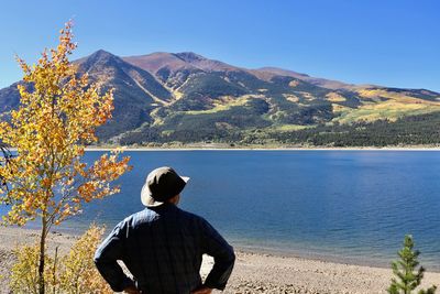 Rear view of man looking at mountain against sky