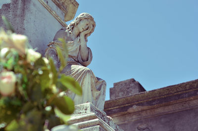 Low angle view of statue against blue sky