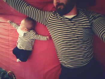 Portrait of man and baby lying on bed