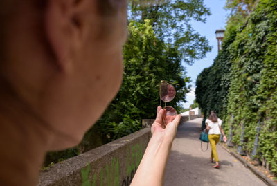 Close-up of woman holding sunglasses with reflection