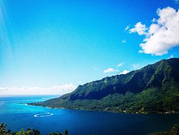 Scenic view of sea and mountains against blue sky